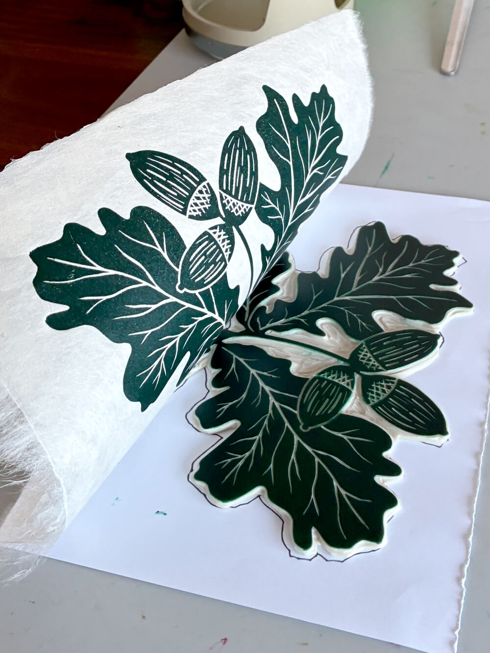 Linocut block being printed onto textured paper.
