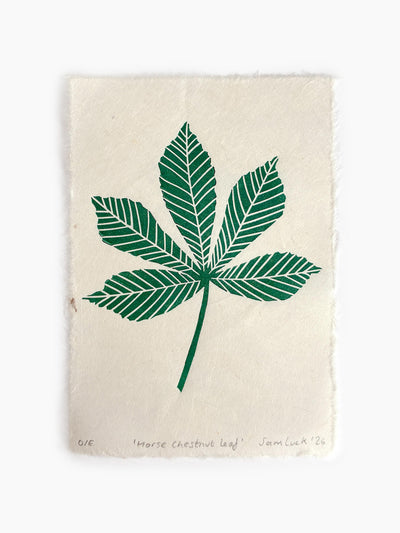 An art print on handmade off-white paper featuring a green chestnut leaf block print. Created by Sam Luck in Hampshire, UK.