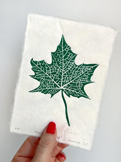 Hand holding a small botanical leaf linocut print of a maple leaf. Thoughtful gift for gardeners and nature lovers.