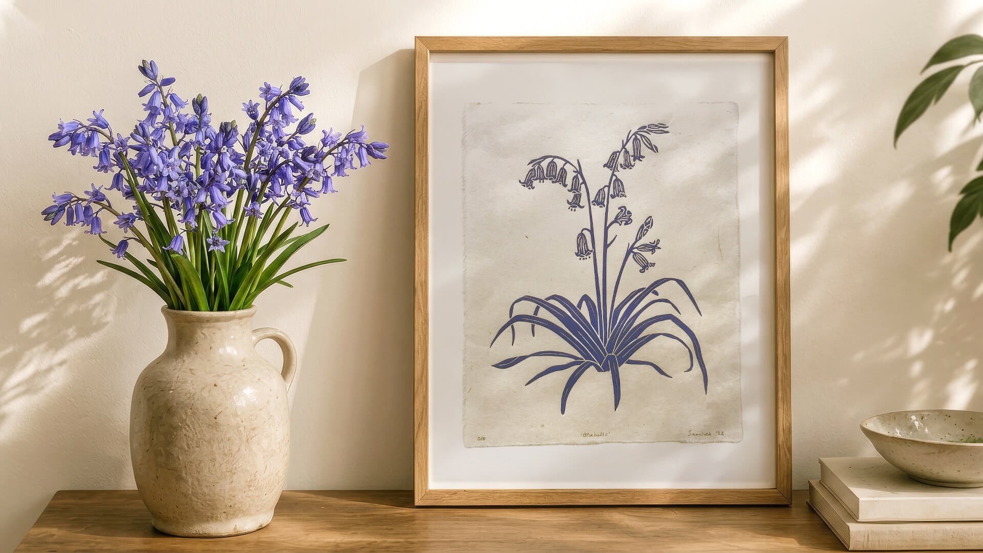 Bluebell botanical linocut wall art print decor. On a table with a vase of English bluebells.