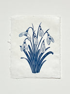 Handmade snowdrops linocut print on handmade paper in blue, full view from above on white background, hand printed by UK linocut artist Sam Luck