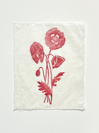 Handmade wild poppies linocut print on handmade paper, view from above, isolated on white background hand printed by UK linocut artist Sam Luck
