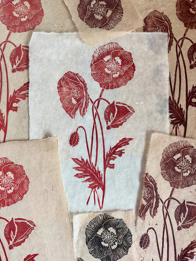 Handmade wild poppies linocut print in red on handmade paper, hand printed by UK linocut artist Sam Luck